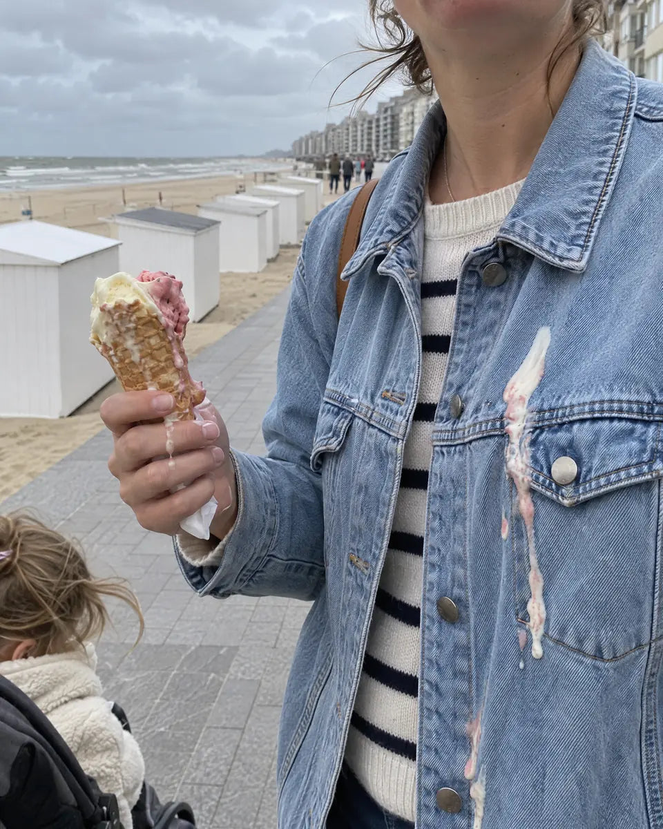 IJsje dat over een jeansjas druipt op de dijk aan zee